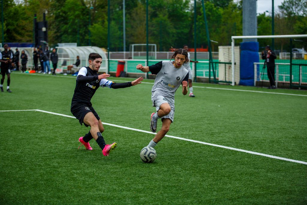 Deux jeunes joueurs de football en plein duel sur le terrain lors d’un match de la catégorie U15 à U19.