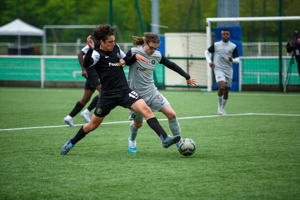 Deux jeunes joueurs de football en plein duel sur le terrain lors d’un match de la catégorie U15 à U19.