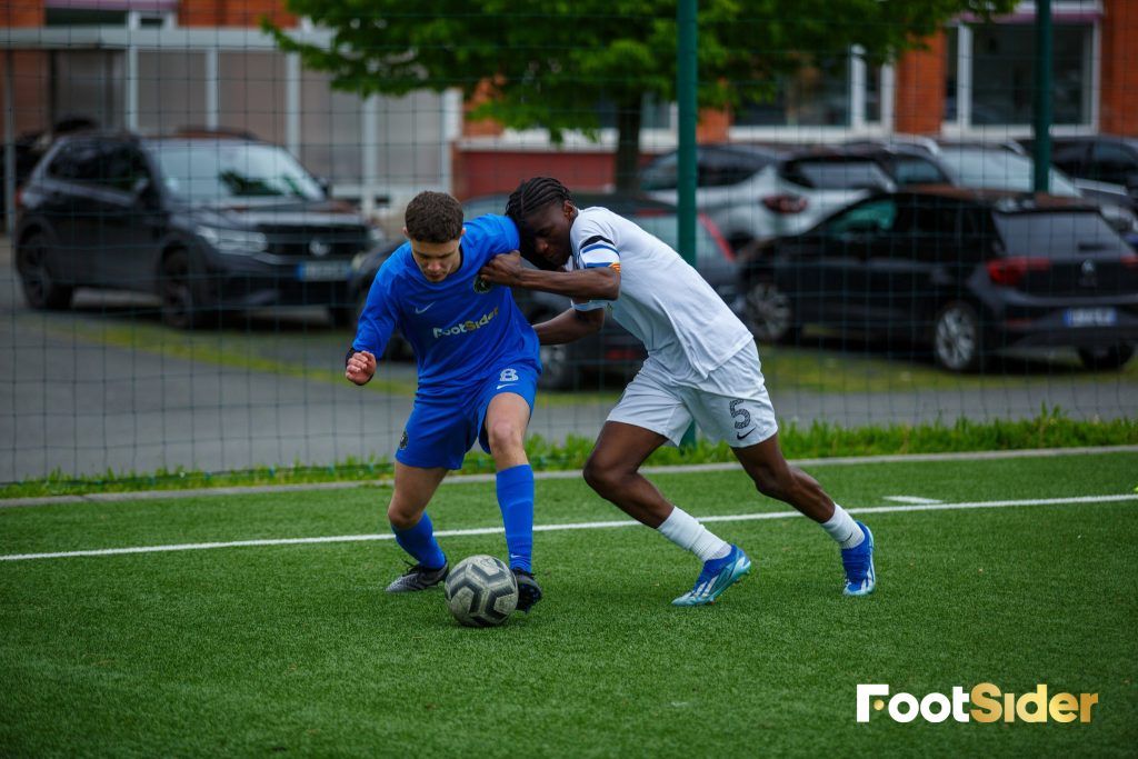 Deux joueurs de football en plein duel sur un terrain pendant un match d’entraînement.