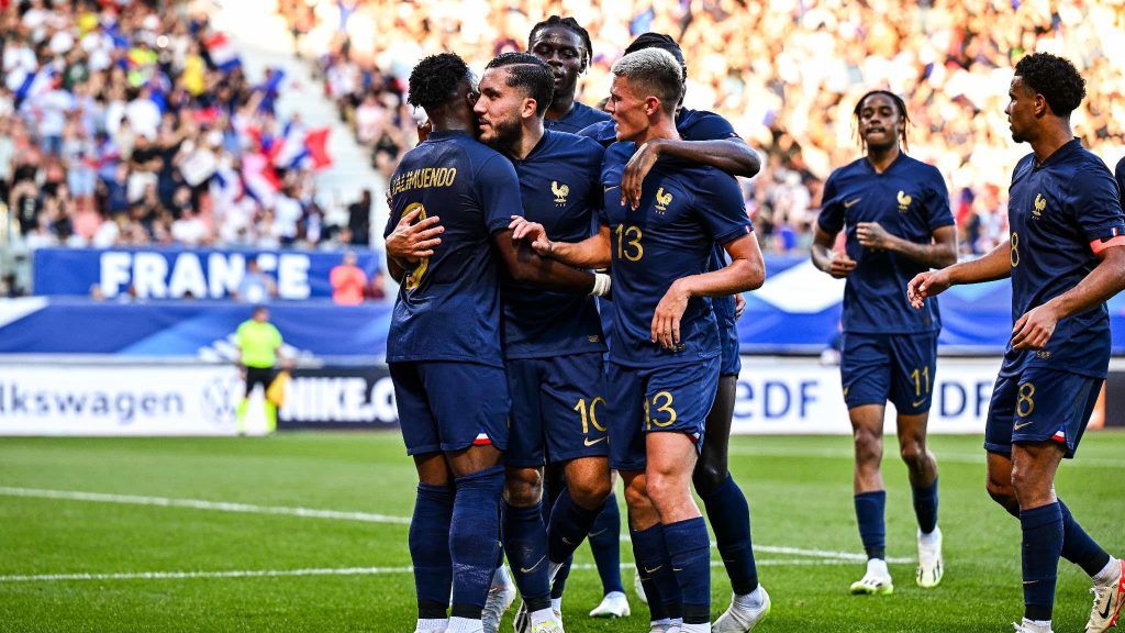 Groupe de jeunes footballeurs en équipes de France espoir célébrant un but lors d'un match.